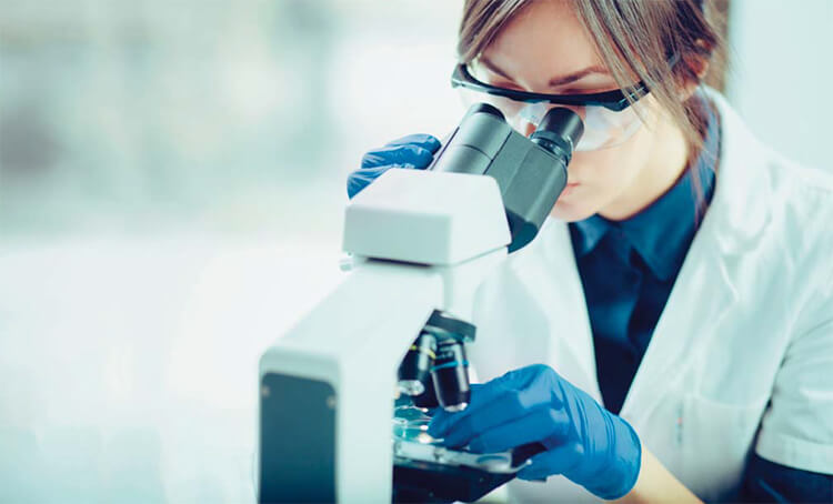 Woman looking through a microscope.