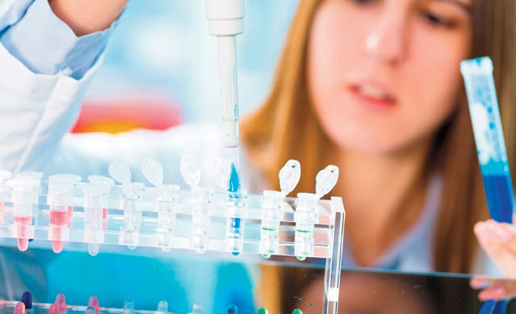Woman in lab filling test tubes
